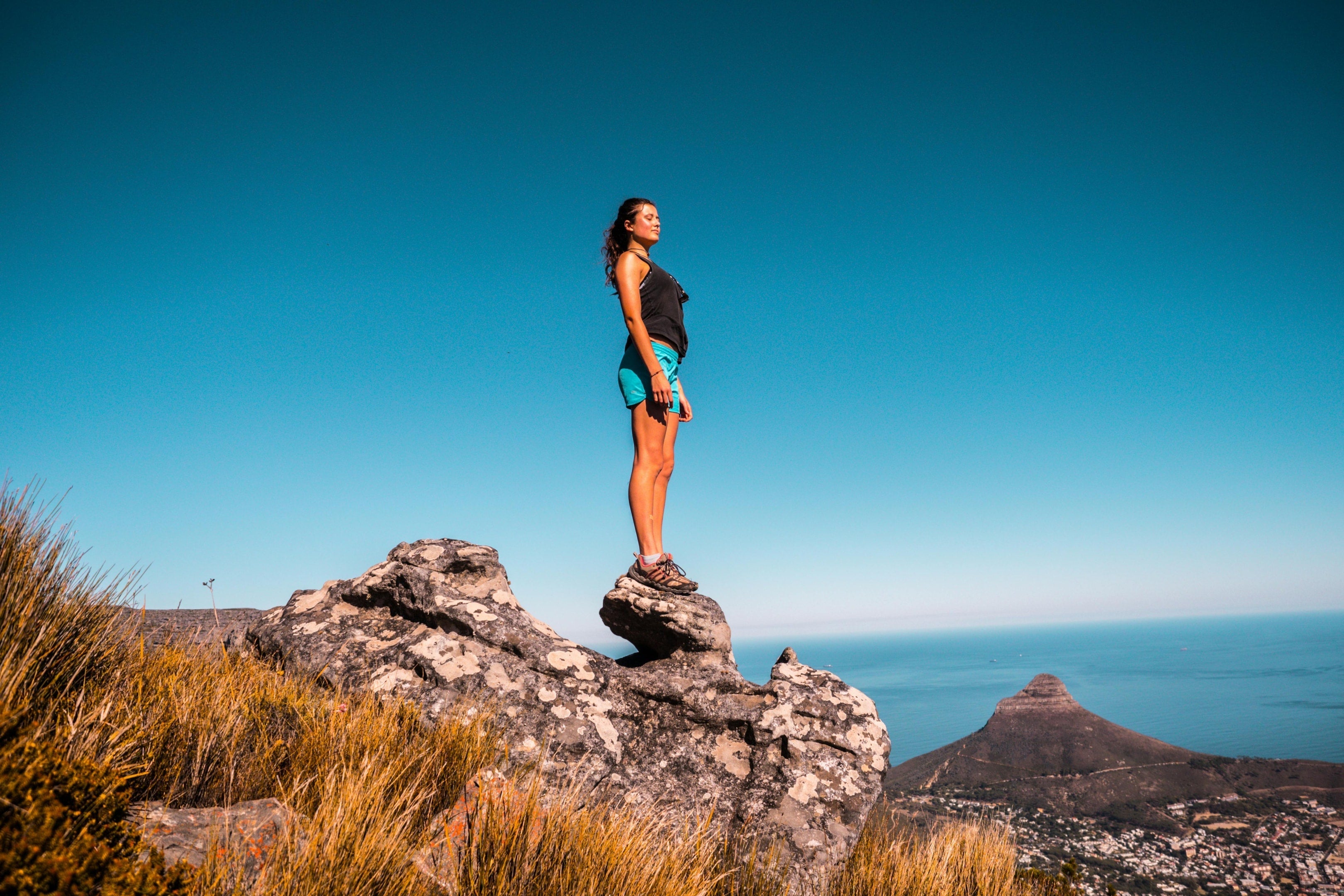 Photo by Tembela Bohle: https://www.pexels.com/photo/woman-in-black-top-and-blue-shorts-on-stone-under-blue-sky-920038/