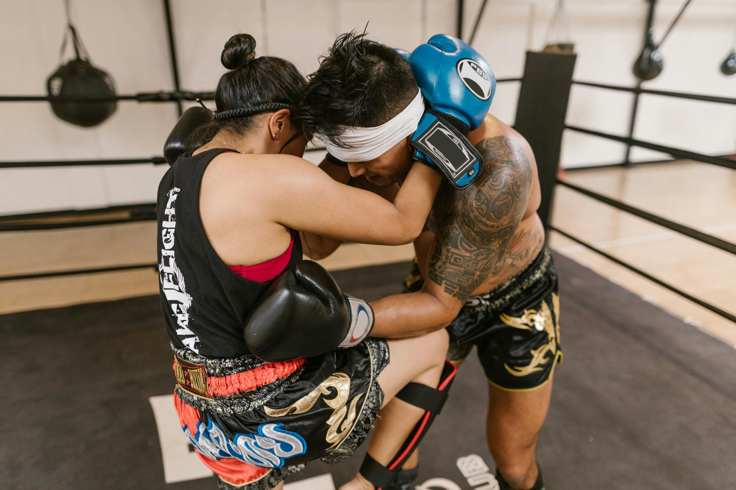 Photo by RDNE Stock project: https://www.pexels.com/photo/a-woman-in-sports-wear-with-blue-boxing-gloves-kicking-a-man-in-the-sparring-ring-8611252/