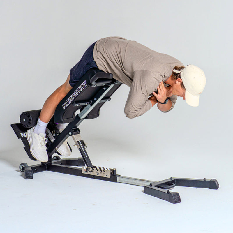 An athlete performing a back extension on the NordBench